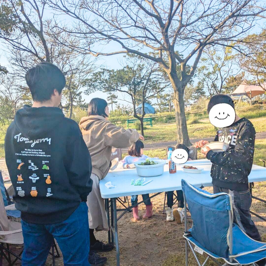 白いテーブルを囲んでバーベキューの食べ物を食べている子どもたちの様子