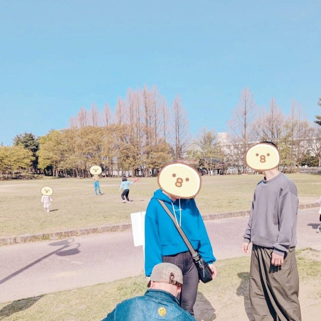 広い公園で遊ぶ５人の子供たちの写真。