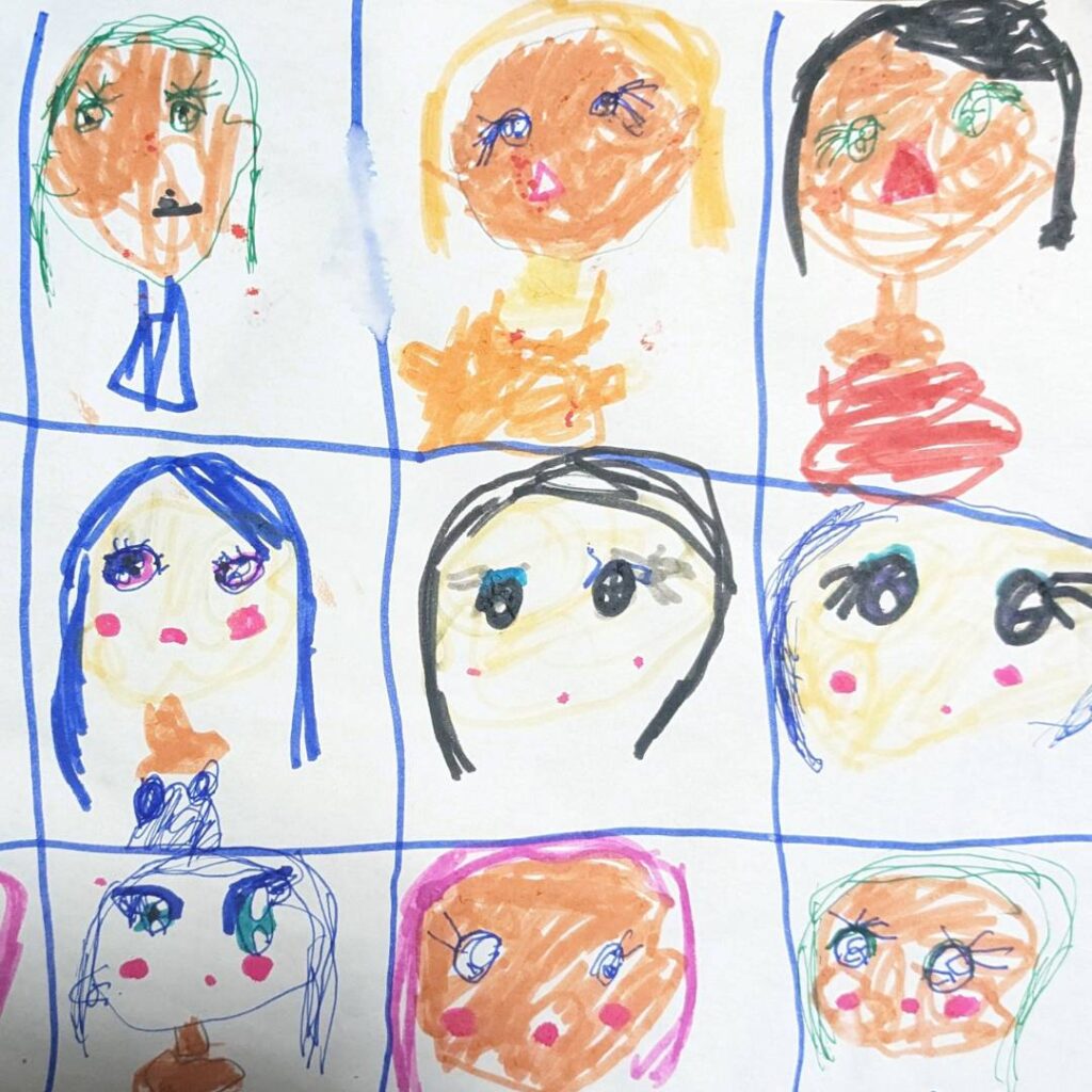 ５歳の女の子が描いた、ブルーや金色、黒など色々な髪や目や肌の色の女性の絵の写真。